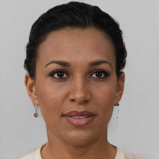 Joyful black young-adult female with short  brown hair and brown eyes