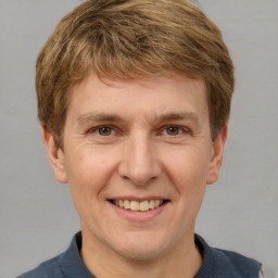 Joyful white adult male with short  brown hair and grey eyes