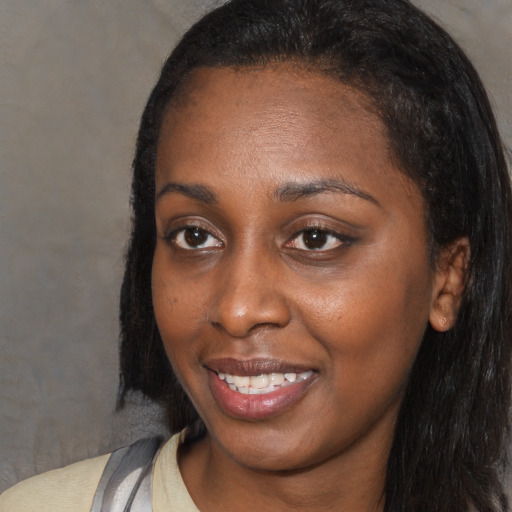 Joyful black young-adult female with long  black hair and brown eyes