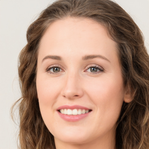 Joyful white young-adult female with long  brown hair and green eyes