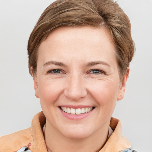 Joyful white adult female with short  brown hair and grey eyes