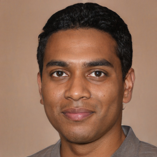 Joyful black young-adult male with short  black hair and brown eyes