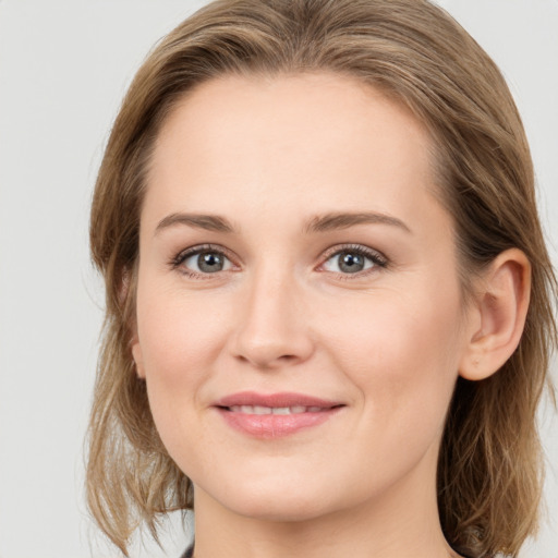 Joyful white young-adult female with medium  brown hair and grey eyes