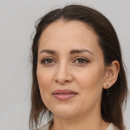 Joyful white adult female with long  brown hair and brown eyes