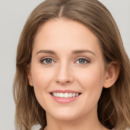 Joyful white young-adult female with long  brown hair and grey eyes