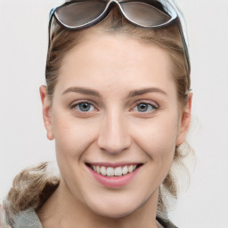 Joyful white young-adult female with long  brown hair and blue eyes