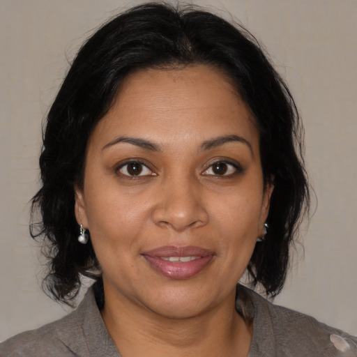 Joyful black adult female with medium  brown hair and brown eyes