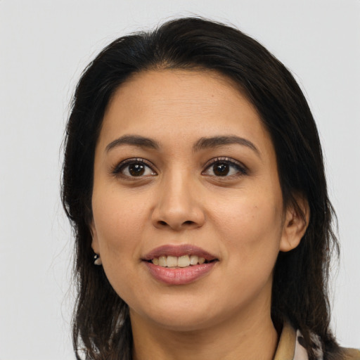 Joyful latino young-adult female with long  brown hair and brown eyes