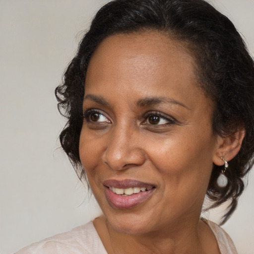 Joyful black adult female with medium  brown hair and brown eyes