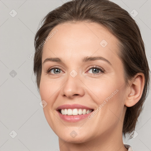 Joyful white young-adult female with medium  brown hair and grey eyes