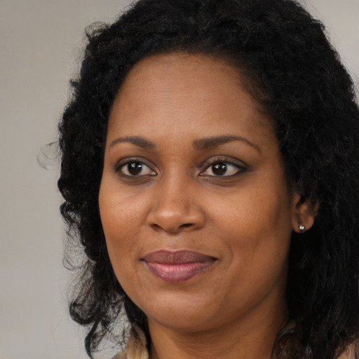 Joyful black adult female with long  brown hair and brown eyes