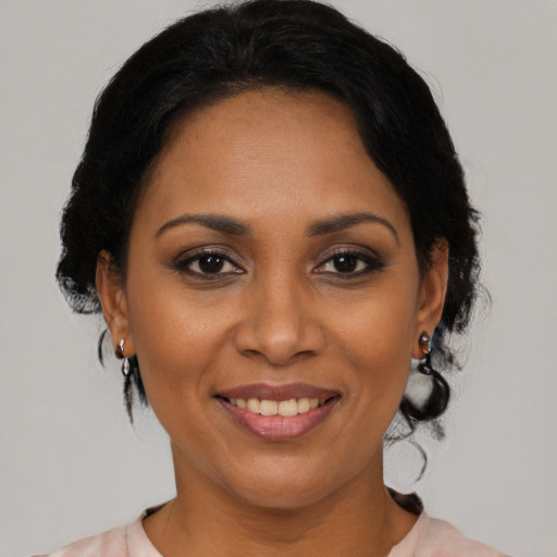 Joyful latino adult female with medium  black hair and brown eyes