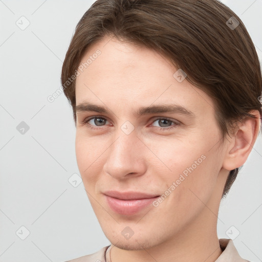 Joyful white young-adult female with short  brown hair and grey eyes