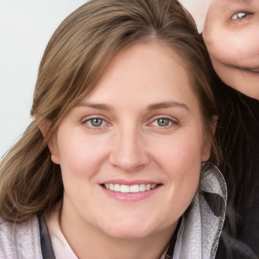 Joyful white young-adult female with medium  brown hair and blue eyes