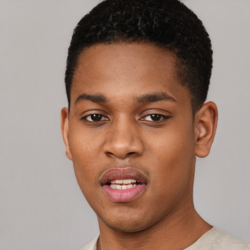 Joyful black young-adult male with short  black hair and brown eyes