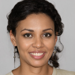 Joyful latino young-adult female with medium  brown hair and brown eyes