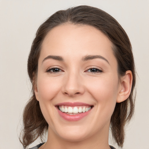 Joyful white young-adult female with medium  brown hair and grey eyes