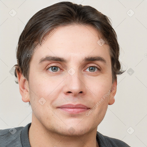 Joyful white young-adult male with short  brown hair and grey eyes