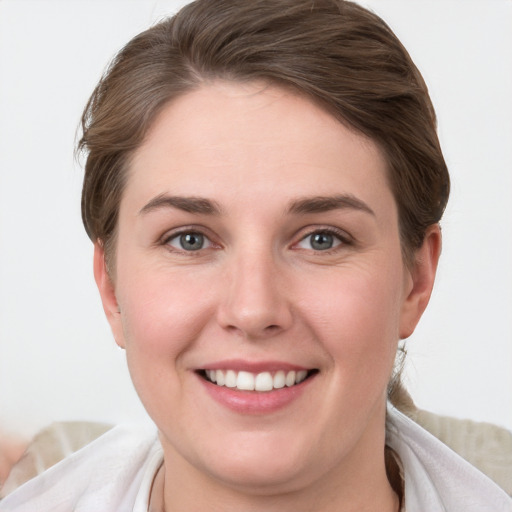 Joyful white young-adult female with short  brown hair and grey eyes