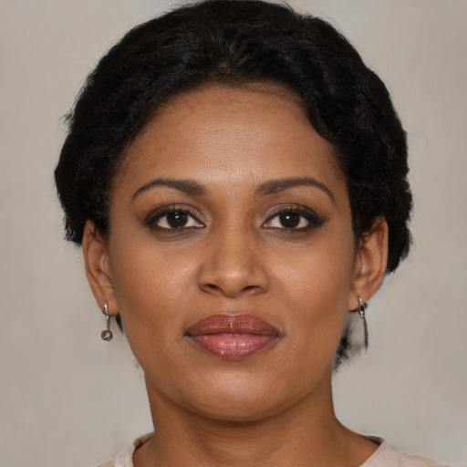 Joyful black young-adult female with short  brown hair and brown eyes