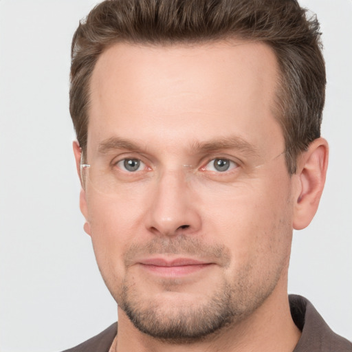 Joyful white adult male with short  brown hair and grey eyes