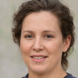 Joyful white adult female with medium  brown hair and grey eyes