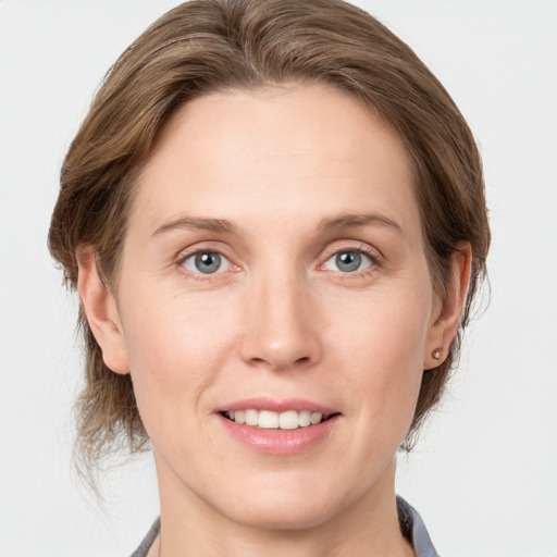 Joyful white young-adult female with medium  brown hair and grey eyes