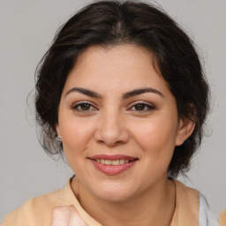 Joyful latino young-adult female with medium  brown hair and brown eyes