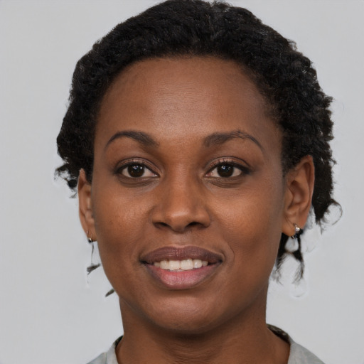 Joyful black adult female with short  brown hair and brown eyes