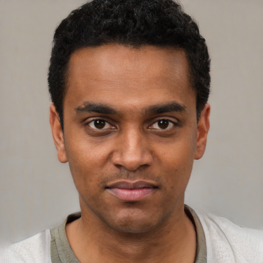 Joyful black young-adult male with short  black hair and brown eyes