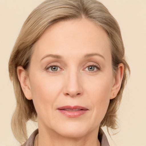 Joyful white adult female with medium  brown hair and grey eyes