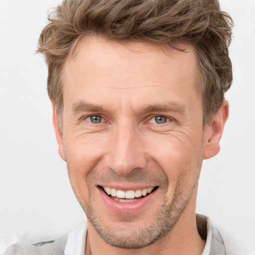 Joyful white adult male with short  brown hair and grey eyes