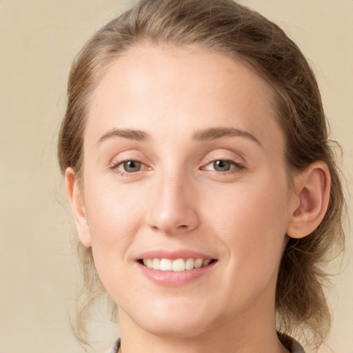 Joyful white young-adult female with medium  brown hair and grey eyes