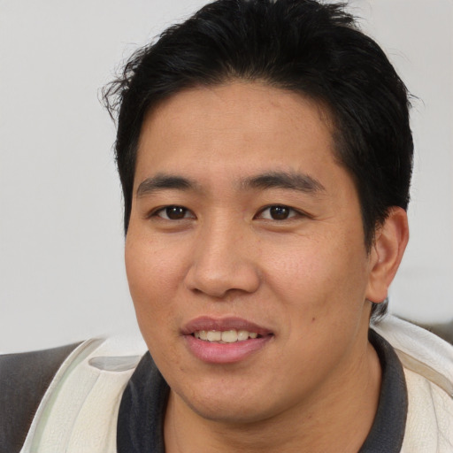 Joyful asian young-adult male with short  brown hair and brown eyes