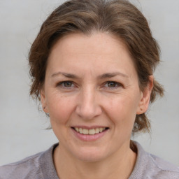 Joyful white adult female with medium  brown hair and grey eyes