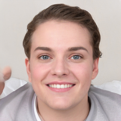 Joyful white young-adult female with short  brown hair and blue eyes