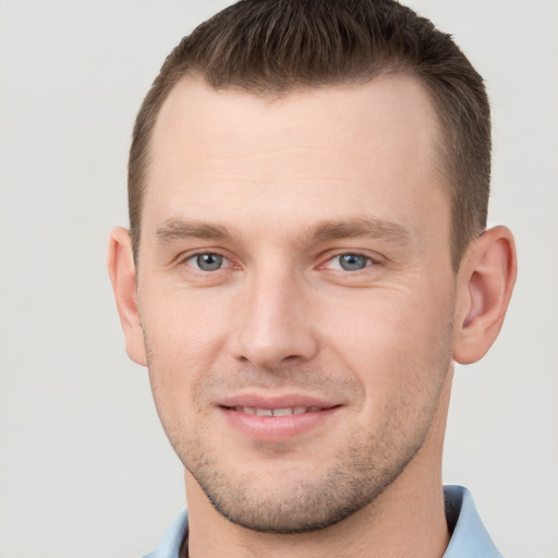 Joyful white young-adult male with short  brown hair and grey eyes