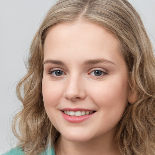 Joyful white young-adult female with long  brown hair and green eyes