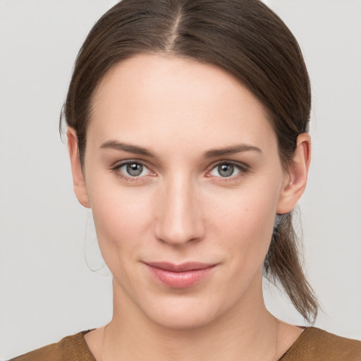 Joyful white young-adult female with medium  brown hair and grey eyes