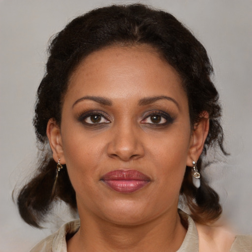 Joyful black adult female with medium  brown hair and brown eyes
