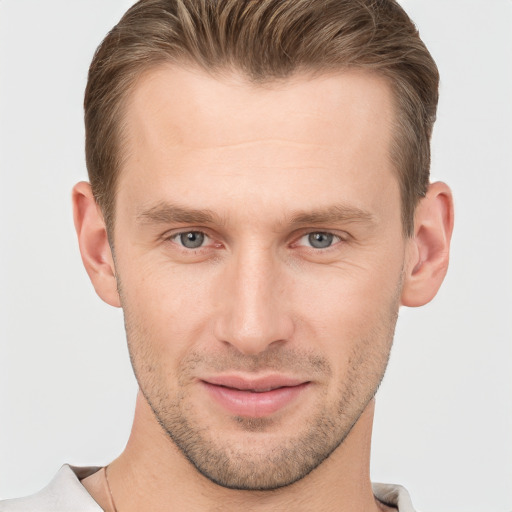 Joyful white young-adult male with short  brown hair and grey eyes