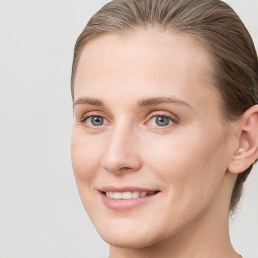 Joyful white young-adult female with short  brown hair and grey eyes