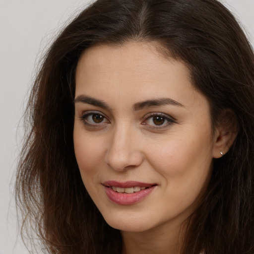 Joyful white young-adult female with long  brown hair and brown eyes