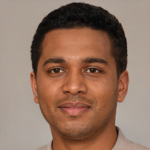 Joyful black young-adult male with short  black hair and brown eyes