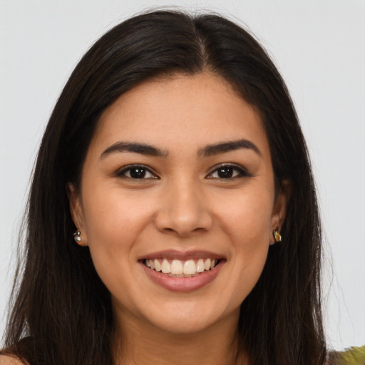 Joyful latino young-adult female with long  brown hair and brown eyes