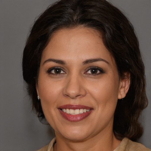 Joyful white adult female with medium  brown hair and brown eyes