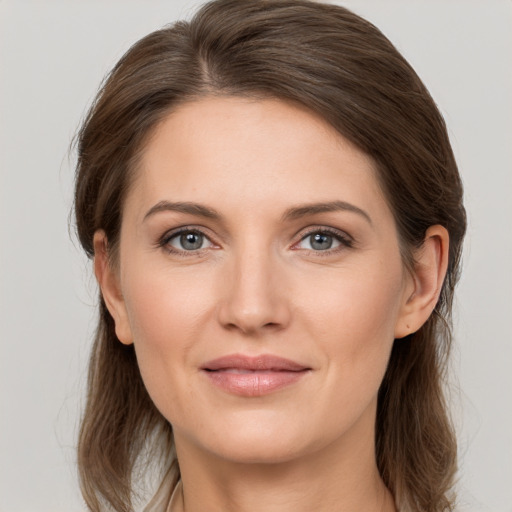 Joyful white young-adult female with medium  brown hair and grey eyes