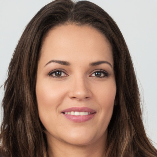 Joyful white young-adult female with long  brown hair and brown eyes