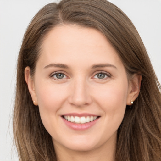 Joyful white young-adult female with long  brown hair and grey eyes