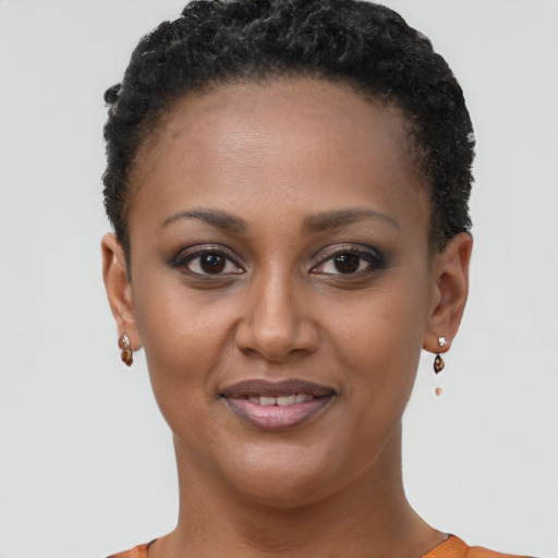 Joyful black young-adult female with short  brown hair and brown eyes
